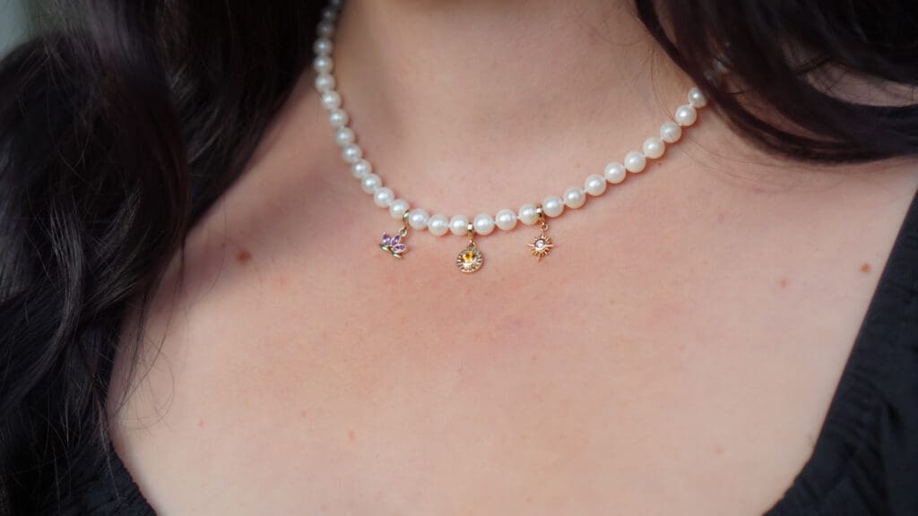 The Akoya Pearl strand, Lotus Flower Charm, Sunburst Charm and Ai Khanum Star Diamond Charm. Photo by Chloe Beaumont